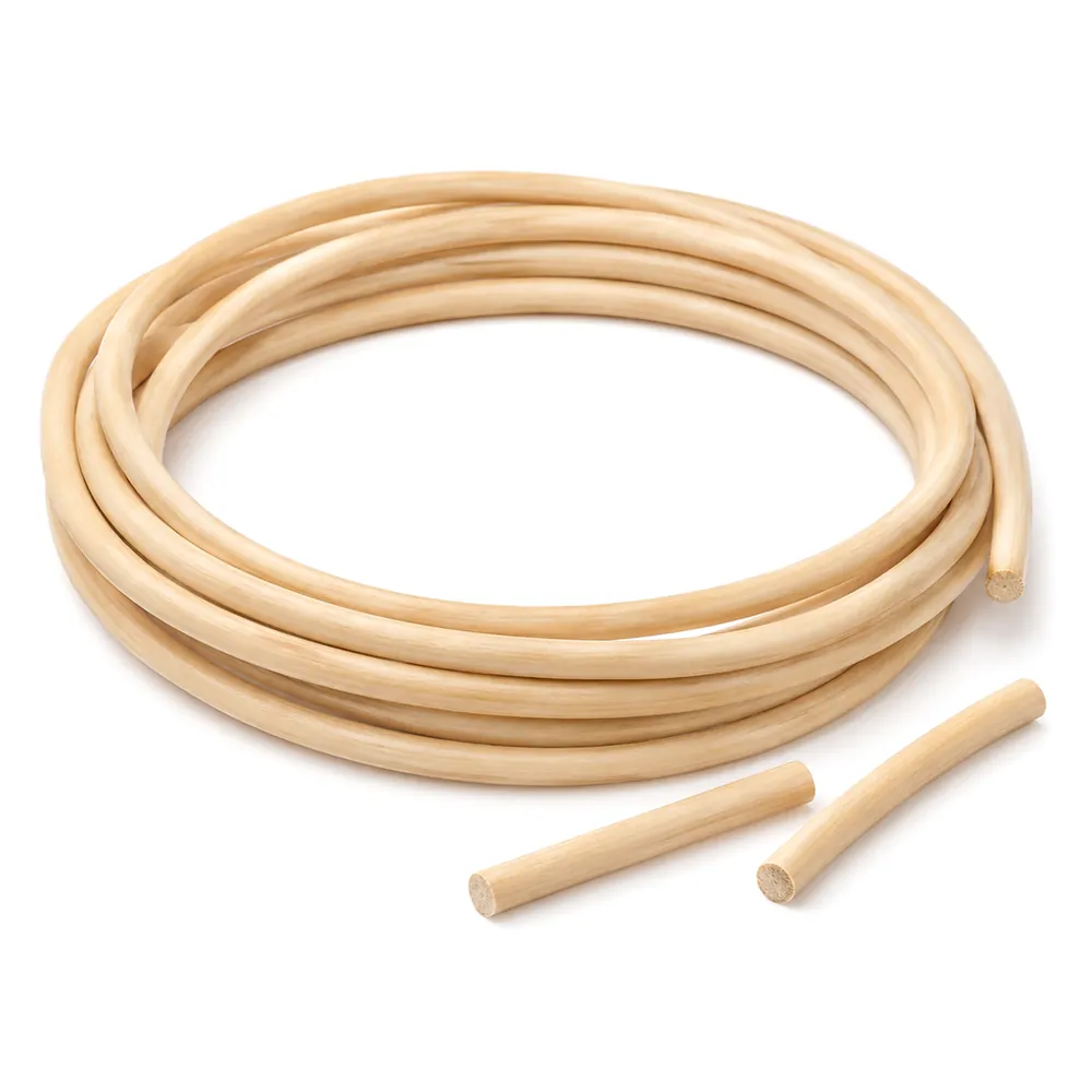 Coil of natural reed spline with two short cut pieces lying beside it on a white background