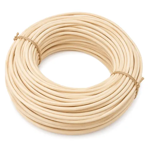 Large coil of natural reed spline loosely tied with two twists of twine on a white background