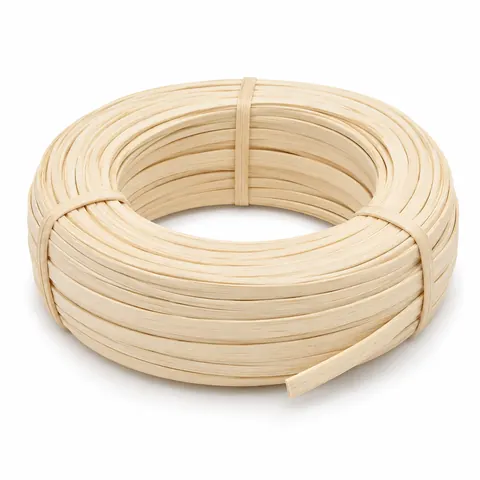 Coil of matte, pale cream flat reed strips about 1/2 in wide, tied, on a white background