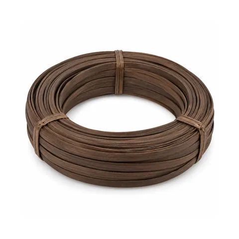 Coil of smoked flat reed in an even deep brown, strips about 1/2 in wide, tied, on a white background