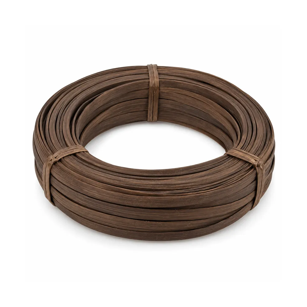 Coil of smoked flat reed in an even deep brown, strips about 1/2 in wide, tied, on a white background