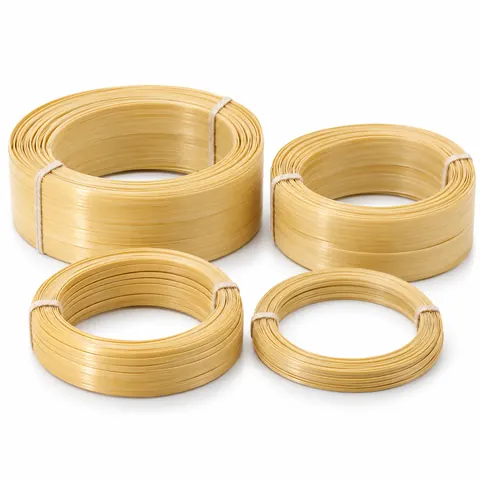 Neat coils of flat split bamboo strips in four widths, glossy pale yellow skin side up, tied with string, on white