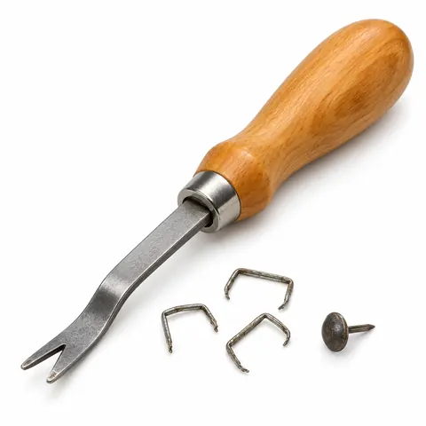 Flat notched staple lifter with a wooden handle beside a few bent old staples and a tack, on a white background