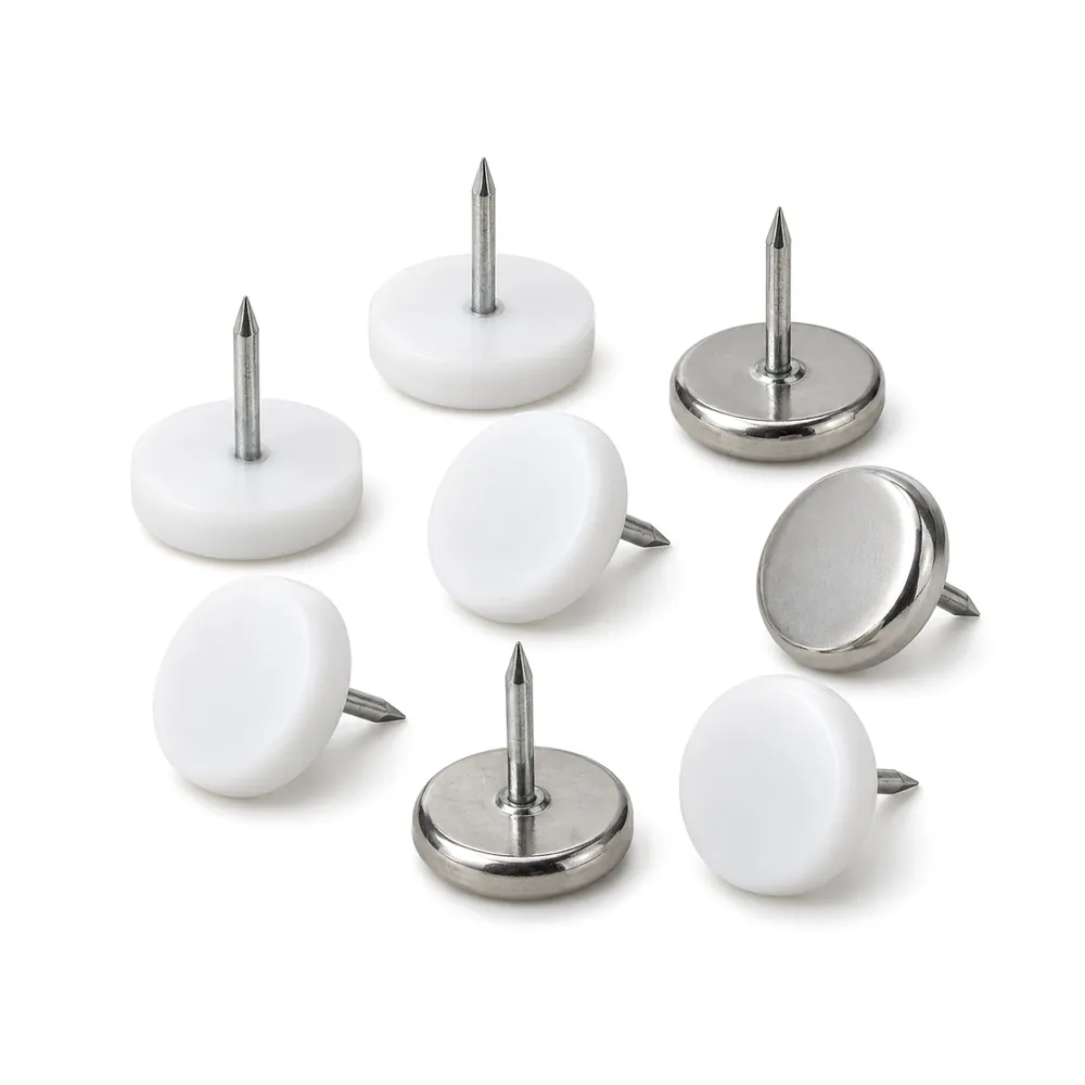 Nail-on furniture glides in white PTFE and silver metal, some upturned to show the nails, on a white background